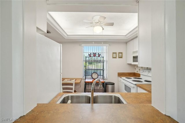 kitchen with white appliances, a ceiling fan, light countertops, white cabinetry, and a sink