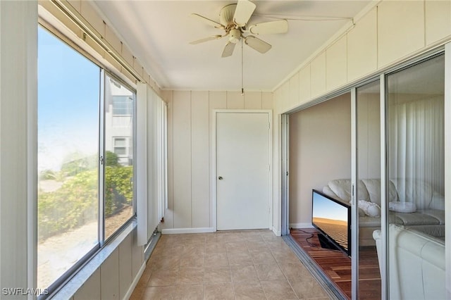 sunroom / solarium with a ceiling fan