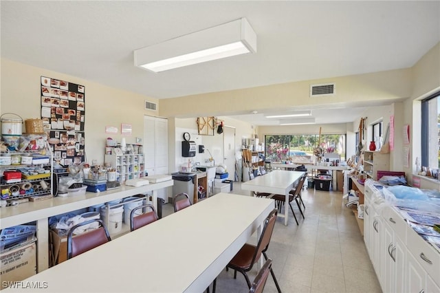 kitchen featuring light countertops, a breakfast bar area, visible vents, and white cabinetry