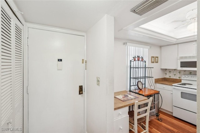 kitchen with white appliances, visible vents, a ceiling fan, light wood-type flooring, and white cabinetry