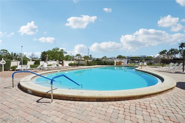 community pool featuring a patio area and fence