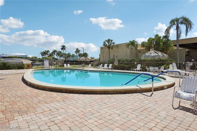 community pool featuring fence and a patio