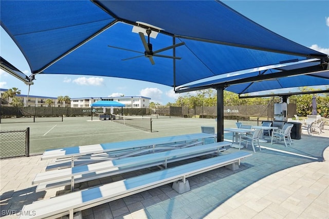 exterior space featuring a tennis court and fence