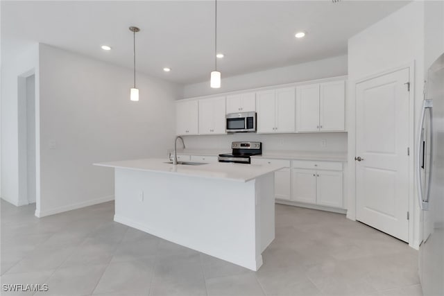 kitchen featuring white cabinets, an island with sink, appliances with stainless steel finishes, light countertops, and a sink