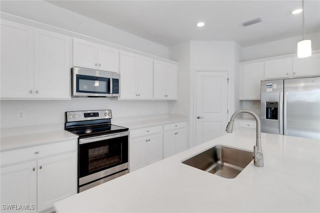 kitchen with stainless steel appliances, recessed lighting, light countertops, white cabinets, and a sink