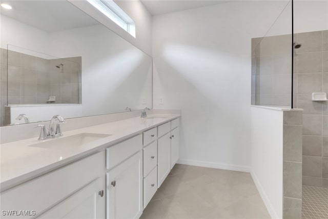 bathroom with double vanity, baseboards, walk in shower, and a sink