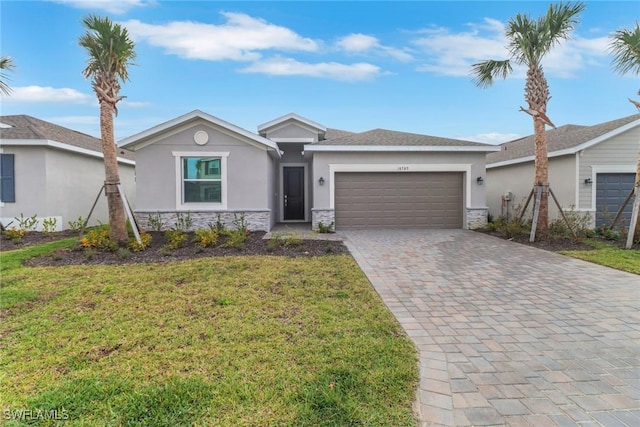 single story home featuring a garage, stone siding, decorative driveway, and stucco siding