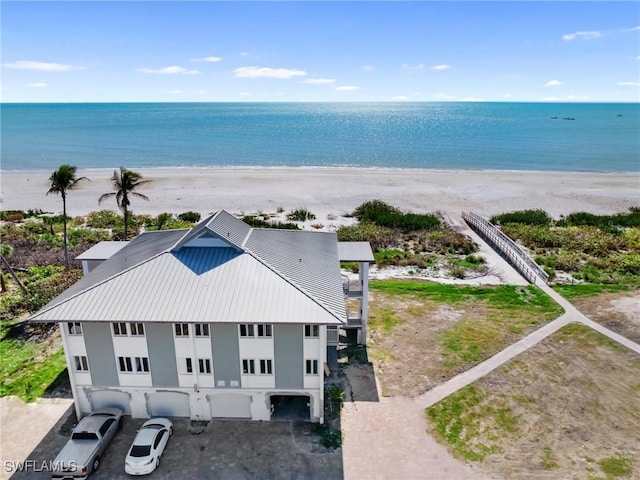 bird's eye view featuring a water view and a beach view