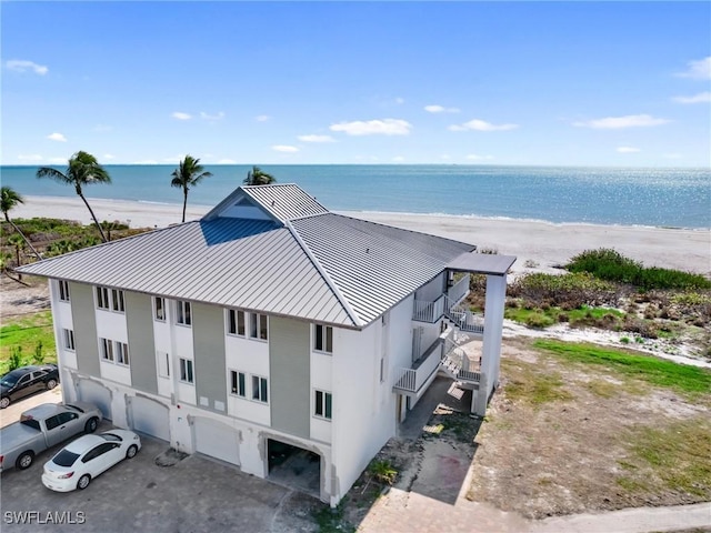 birds eye view of property featuring a water view and a beach view