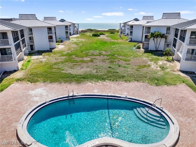 pool with a water view and a residential view