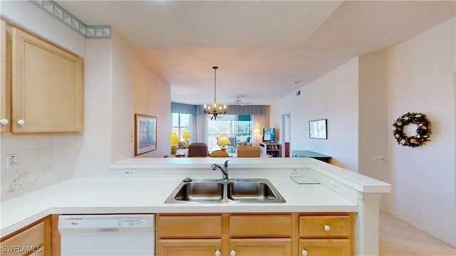 kitchen with light brown cabinets, a peninsula, a sink, light countertops, and dishwasher