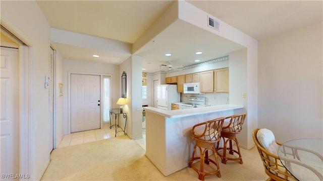 kitchen with recessed lighting, light countertops, visible vents, light carpet, and white appliances