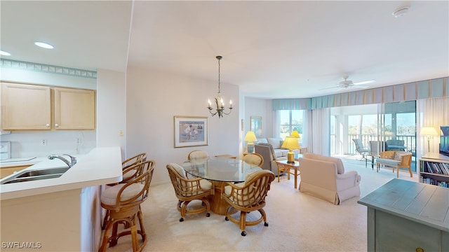 dining room with ceiling fan with notable chandelier, recessed lighting, and light colored carpet