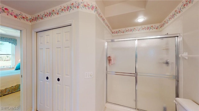 full bathroom featuring a stall shower, a closet, and toilet