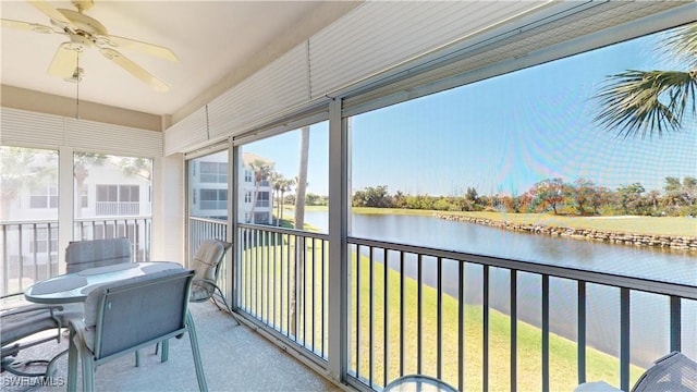 sunroom / solarium with a ceiling fan, a healthy amount of sunlight, and a water view