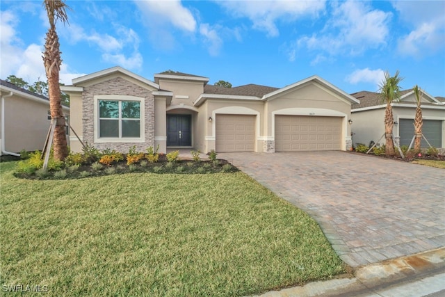 view of front of home featuring a garage, decorative driveway, a front lawn, and stucco siding