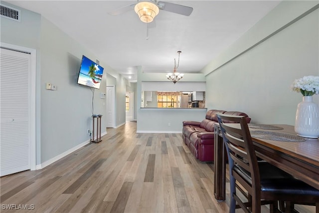 living area with baseboards, visible vents, and wood finished floors