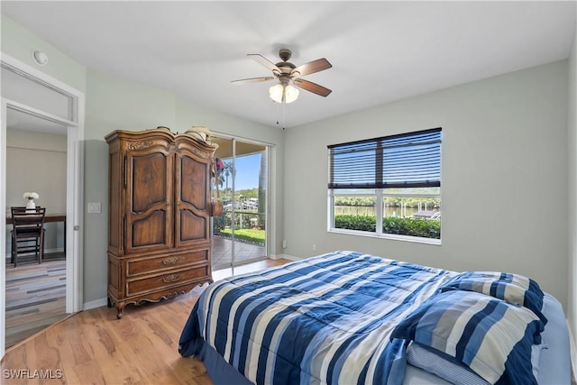 bedroom featuring access to exterior, light wood-type flooring, multiple windows, and baseboards