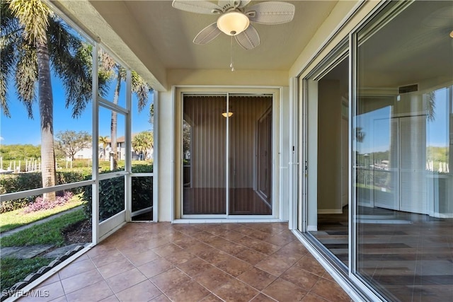 unfurnished sunroom with a ceiling fan