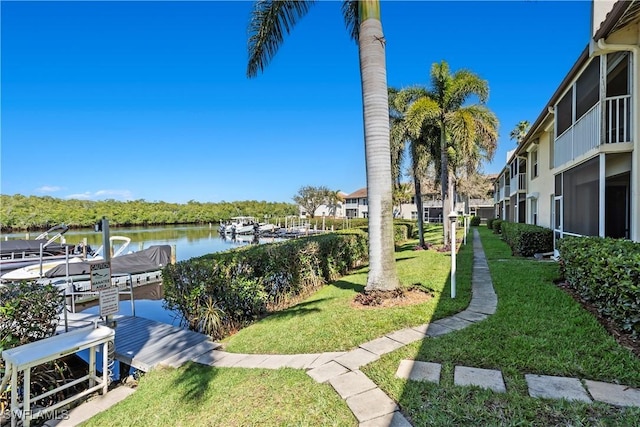 surrounding community with a yard, a boat dock, and a water view