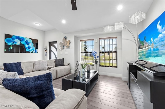 living area with a ceiling fan, recessed lighting, light wood-style flooring, and baseboards