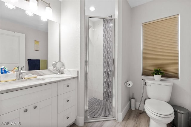 full bathroom featuring baseboards, toilet, wood finished floors, vanity, and a shower stall