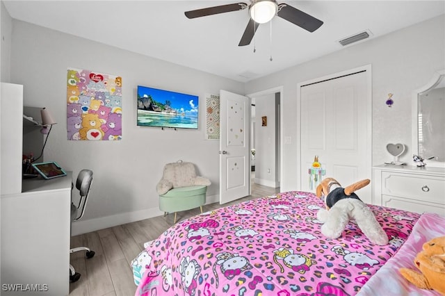 bedroom featuring light wood finished floors, baseboards, visible vents, a ceiling fan, and a closet