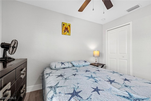 bedroom featuring a closet, visible vents, ceiling fan, wood finished floors, and baseboards