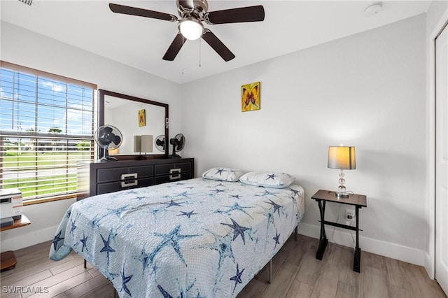 bedroom with ceiling fan, baseboards, and wood finished floors