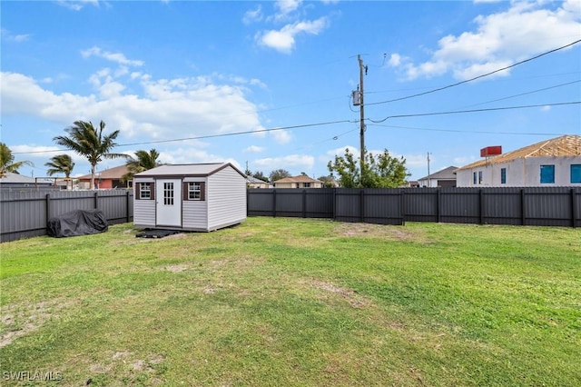 view of yard with a fenced backyard, an outdoor structure, and a shed