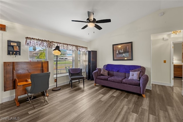 living room with a ceiling fan, vaulted ceiling, baseboards, and wood finished floors