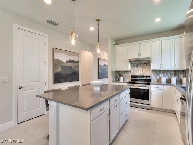 kitchen with stainless steel gas stove, dark countertops, and white cabinets