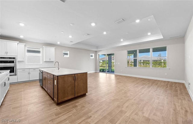 17333 Leaning Oak Trl, North Fort Myers, FL 33917 - kitchen featuring a raised ceiling, stainless steel double oven, light countertops, white cabinetry, and recessed lighting