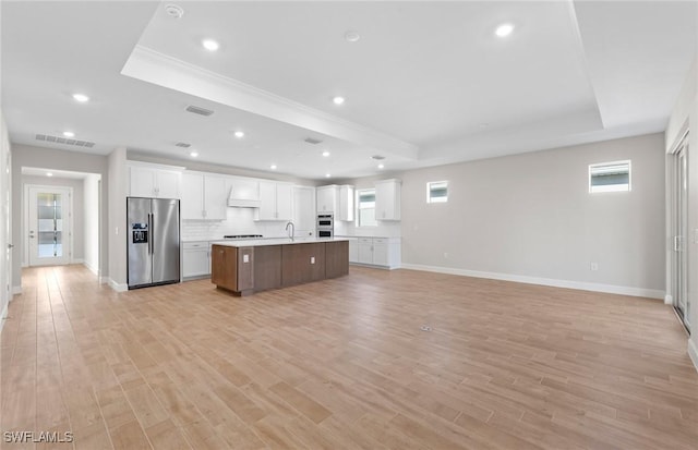 17333 Leaning Oak Trl, North Fort Myers, FL 33917 - kitchen with stainless steel appliances, a raised ceiling, premium range hood, open floor plan, and a kitchen island with sink