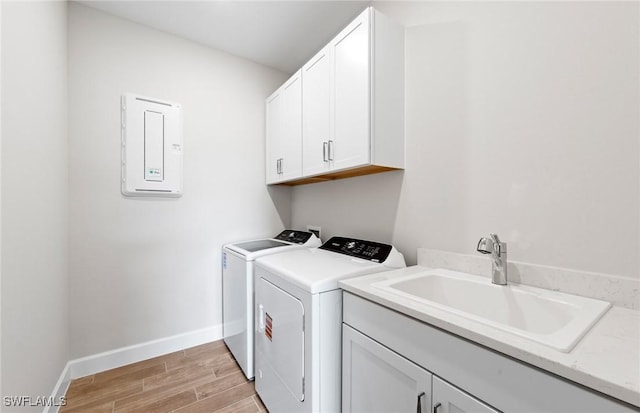 17333 Leaning Oak Trl, North Fort Myers, FL 33917 - washroom featuring washing machine and dryer, cabinet space, baseboards, light wood-type flooring, and electric panel