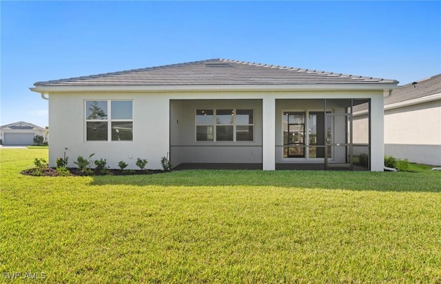 17333 Leaning Oak Trl, North Fort Myers, FL 33917 - rear view of property featuring a lawn, stucco siding, a sunroom, and a tile roof