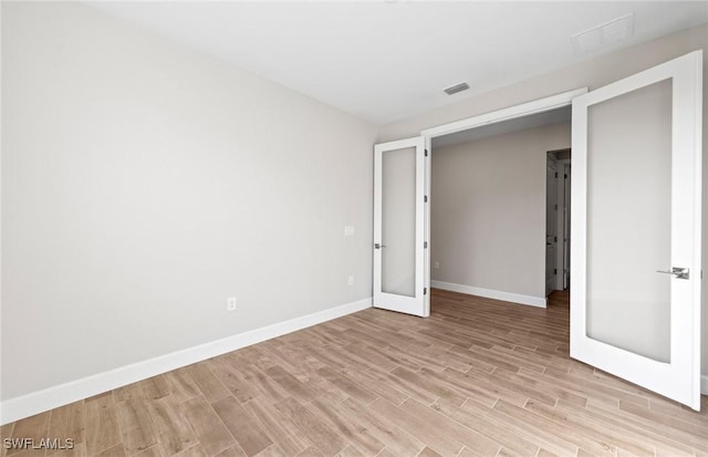 17333 Leaning Oak Trl, North Fort Myers, FL 33917 - unfurnished room featuring light wood-style floors, baseboards, and french doors