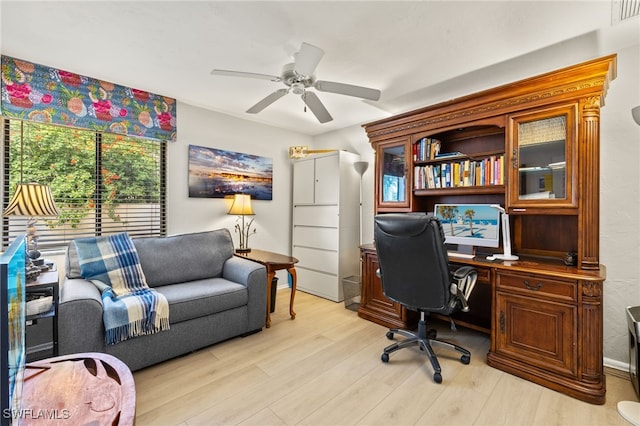 office space featuring light wood-style floors, visible vents, and a ceiling fan