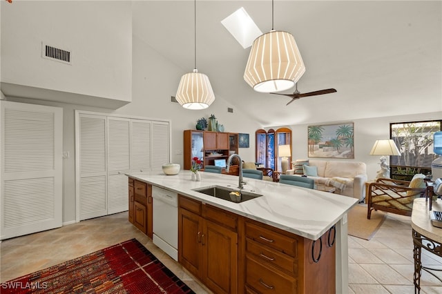 kitchen with dishwasher, open floor plan, hanging light fixtures, a kitchen island with sink, and a sink