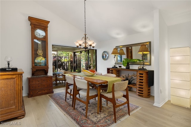 dining space with baseboards, high vaulted ceiling, light wood-style floors, and an inviting chandelier