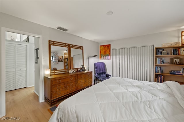 bedroom featuring light wood finished floors and visible vents