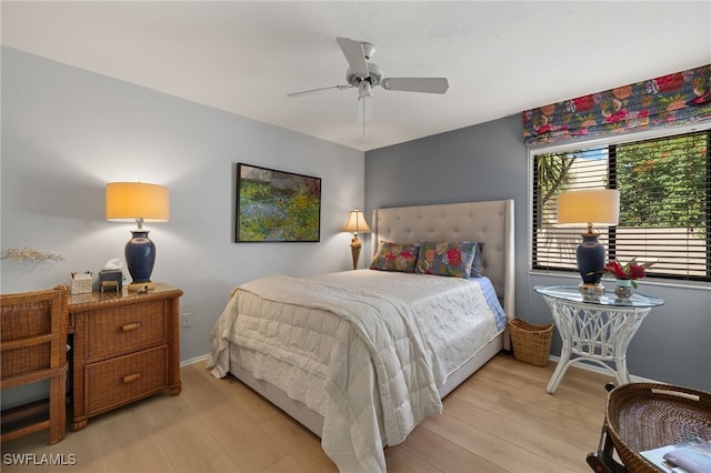 bedroom featuring light wood finished floors, baseboards, and a ceiling fan