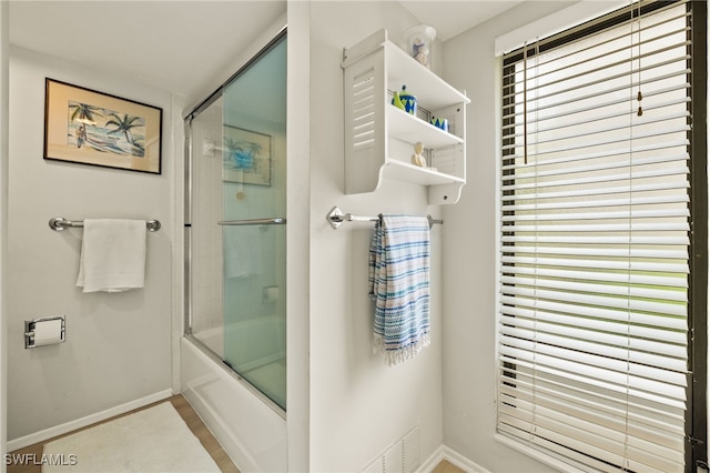 full bathroom featuring enclosed tub / shower combo and baseboards