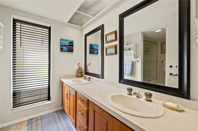 bathroom featuring double vanity, a sink, and a shower with door