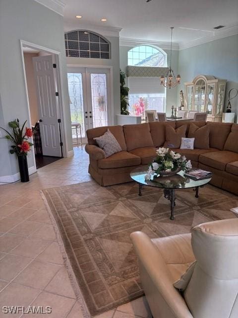 living room with a wealth of natural light, a notable chandelier, crown molding, and light tile patterned floors