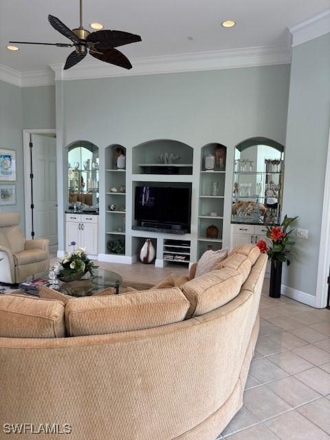 living room with light tile patterned floors, built in features, ceiling fan, and ornamental molding