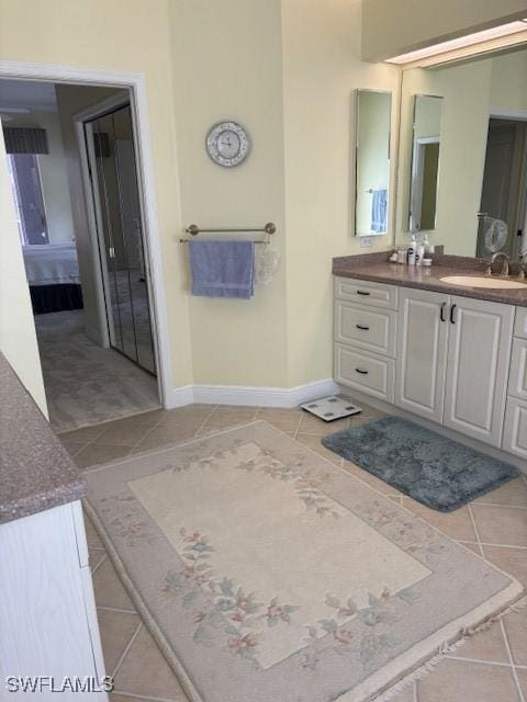 bathroom featuring tile patterned flooring, vanity, and baseboards