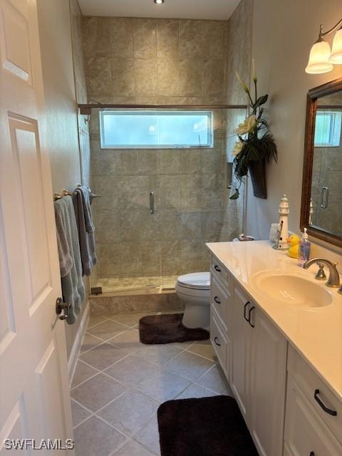 bathroom featuring vanity, a shower stall, toilet, and tile patterned floors