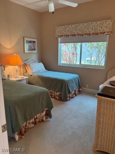 bedroom with a ceiling fan, baseboards, and carpet floors