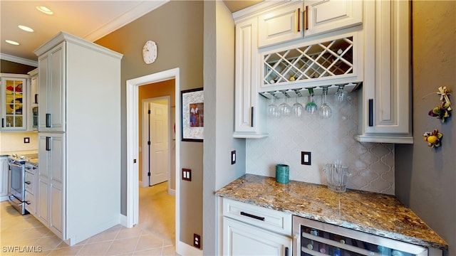 kitchen featuring light stone counters, beverage cooler, light tile patterned floors, electric stove, and tasteful backsplash